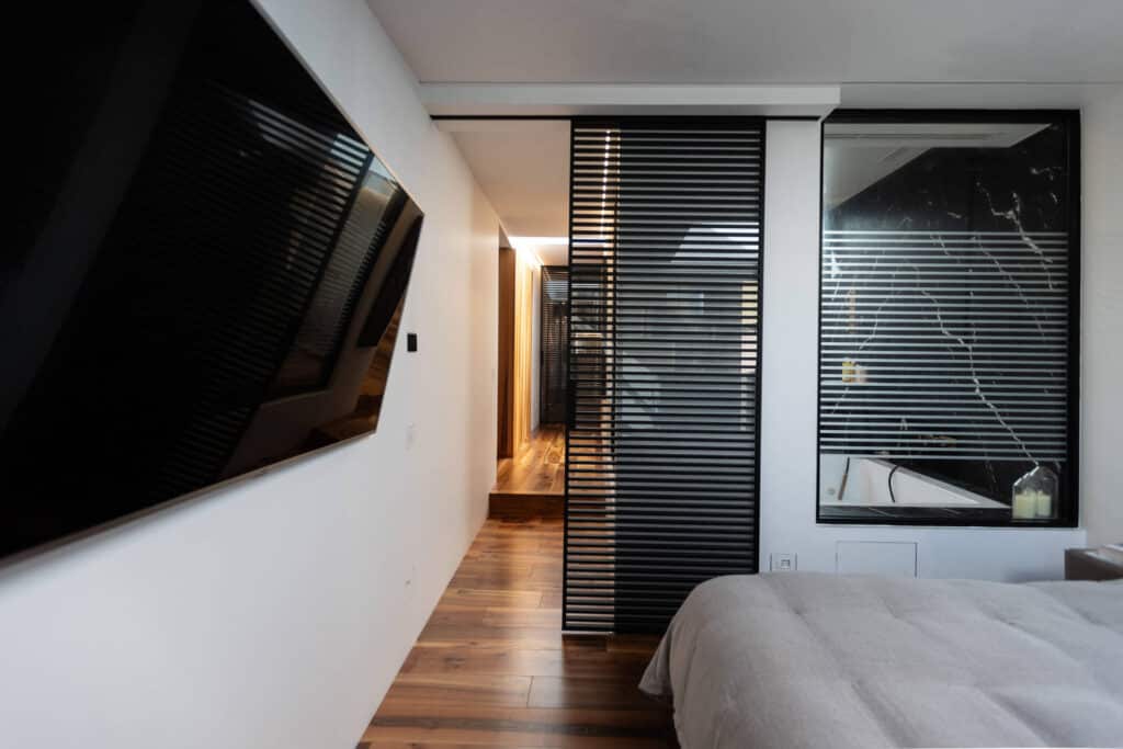Zone notte eleganti e luminose -02 Porte scorrevoli in vetro riflettente Velaria di Rimadesio tra camera e cabina armadio